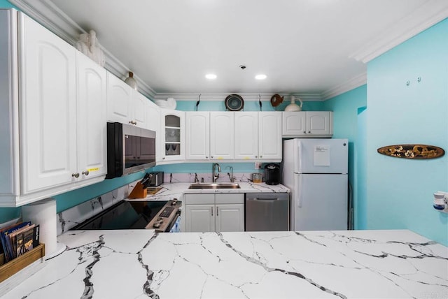 kitchen with white cabinetry, sink, light stone counters, and appliances with stainless steel finishes