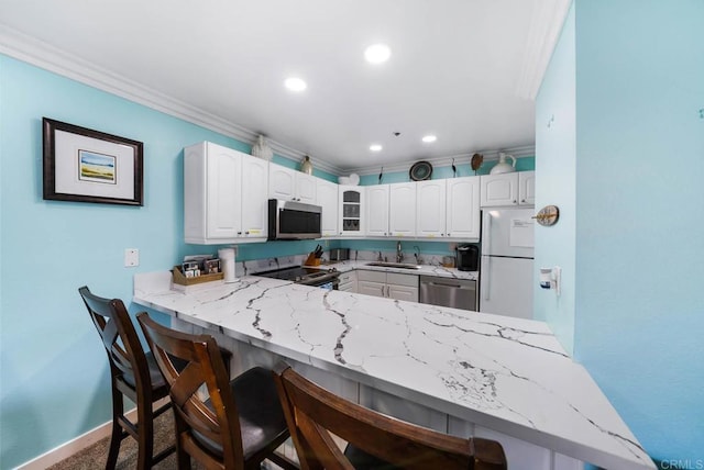 kitchen with a kitchen bar, sink, white cabinetry, kitchen peninsula, and stainless steel appliances