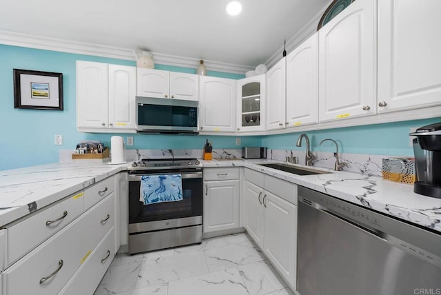 kitchen featuring appliances with stainless steel finishes, white cabinetry, sink, light stone counters, and crown molding