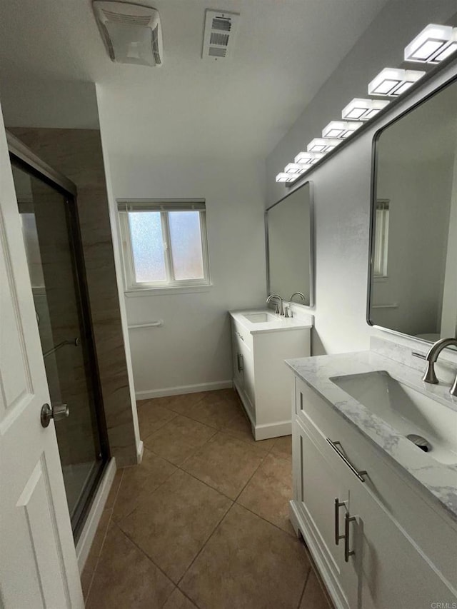 bathroom featuring a stall shower, visible vents, a sink, and tile patterned floors