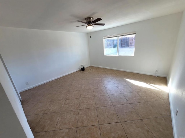 empty room featuring light tile patterned flooring, ceiling fan, and baseboards