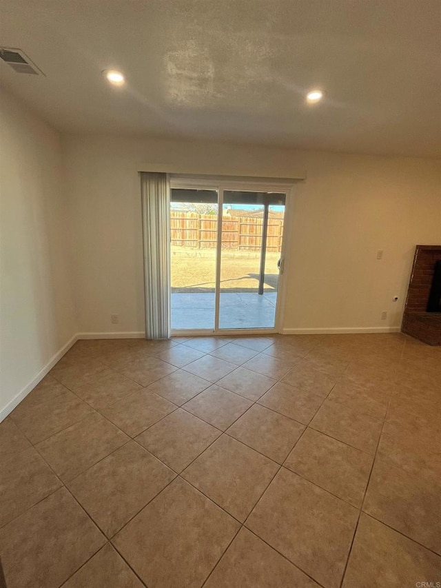 unfurnished room featuring light tile patterned floors, recessed lighting, visible vents, and baseboards