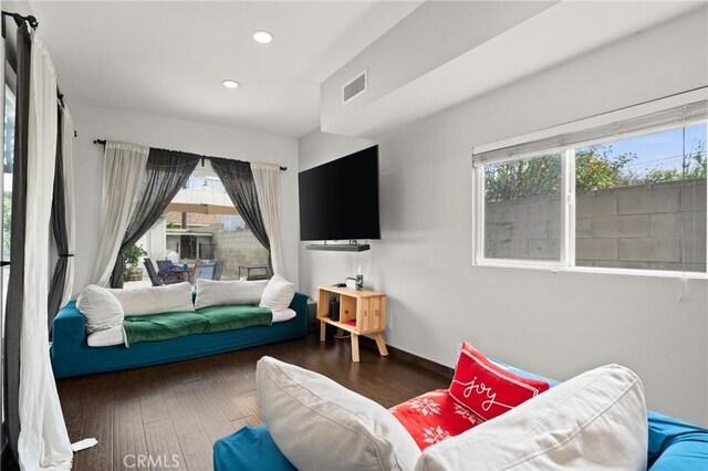 bedroom with multiple windows and dark wood-type flooring