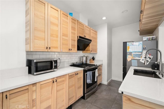 kitchen with light brown cabinets, light countertops, decorative backsplash, range hood, and appliances with stainless steel finishes