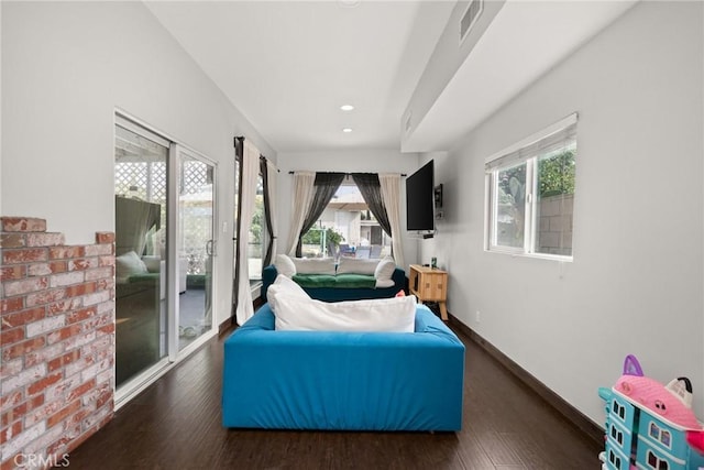 living area with recessed lighting, visible vents, baseboards, and wood finished floors