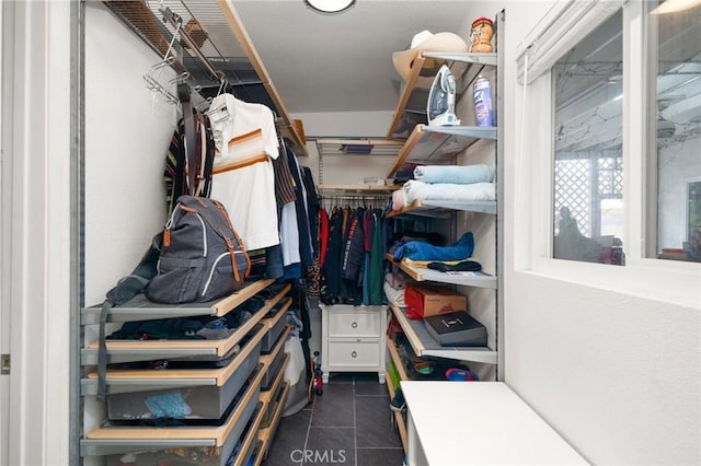 spacious closet featuring dark tile patterned flooring