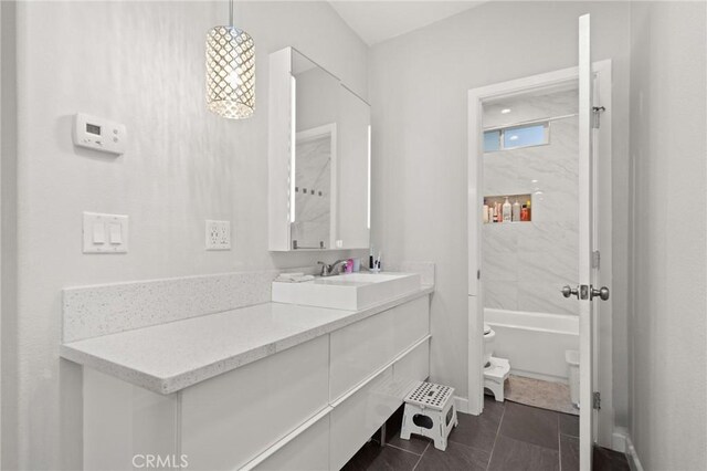 full bathroom with vanity, tiled shower / bath, tile patterned floors, and toilet