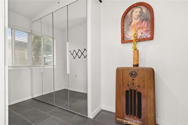 mudroom with dark tile patterned floors