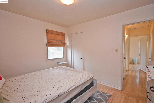 bedroom with light wood-type flooring and a closet