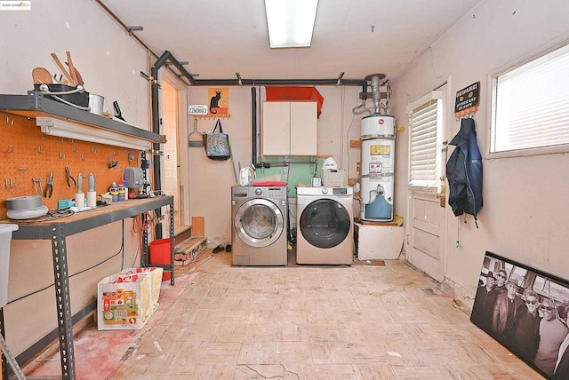 washroom with independent washer and dryer, strapped water heater, and a workshop area