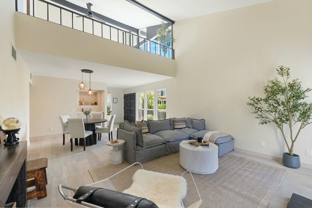 living room with a towering ceiling and light hardwood / wood-style flooring