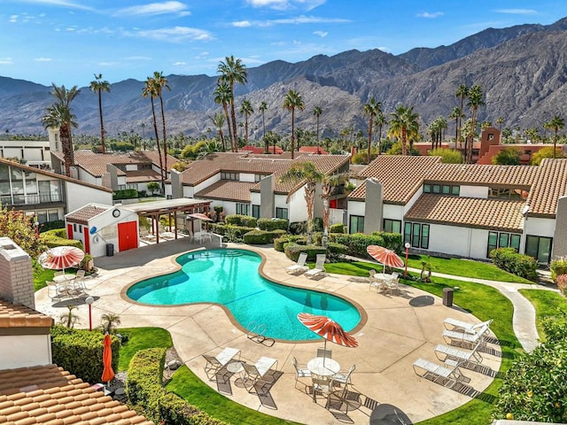 view of swimming pool with a mountain view and a patio area