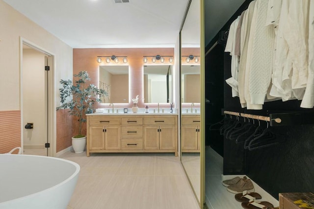 bathroom featuring vanity, a bathing tub, and tile patterned flooring