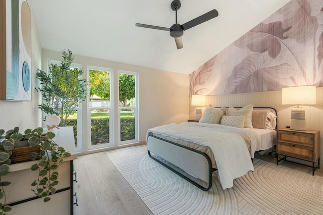 bedroom with ceiling fan, lofted ceiling, and light wood-type flooring