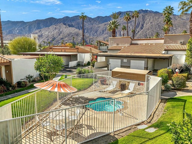 back of property featuring a fenced in pool, a mountain view, and a patio area