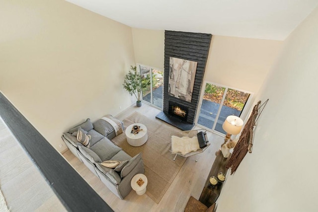 living room featuring a fireplace and high vaulted ceiling