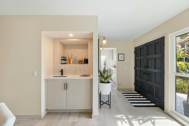 entrance foyer with indoor wet bar and light wood-type flooring