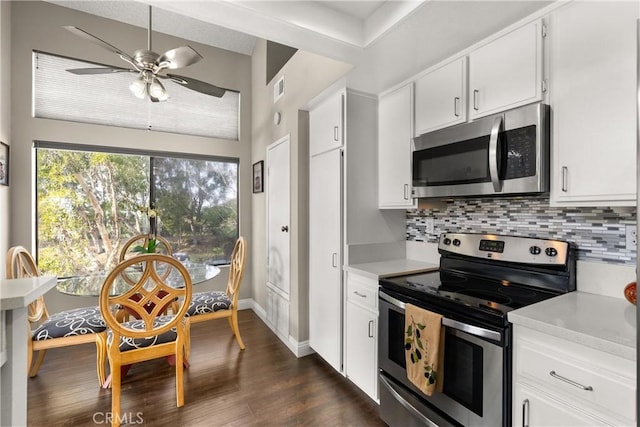 kitchen with white cabinetry, backsplash, stainless steel appliances, and dark hardwood / wood-style floors