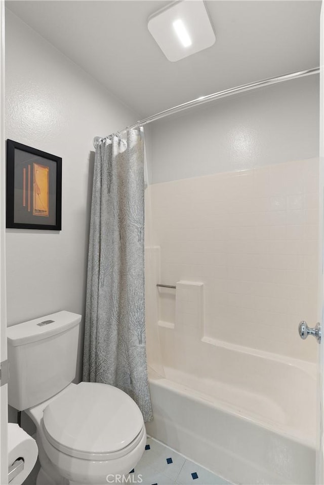 bathroom with toilet, tile patterned flooring, and shower / bath combo