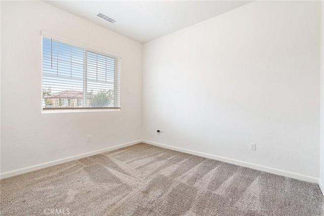 carpeted empty room featuring baseboards and visible vents