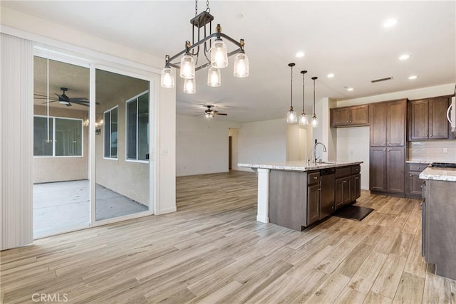 kitchen with dishwasher, light wood finished floors, open floor plan, and a ceiling fan