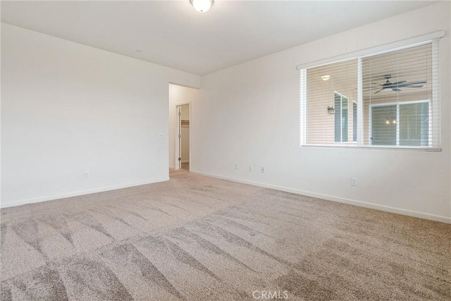 carpeted empty room featuring baseboards