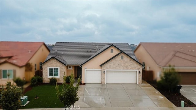 view of front facade with driveway, stone siding, a tiled roof, an attached garage, and a front lawn