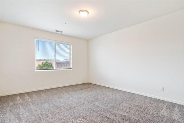 spare room with baseboards, visible vents, and carpet flooring