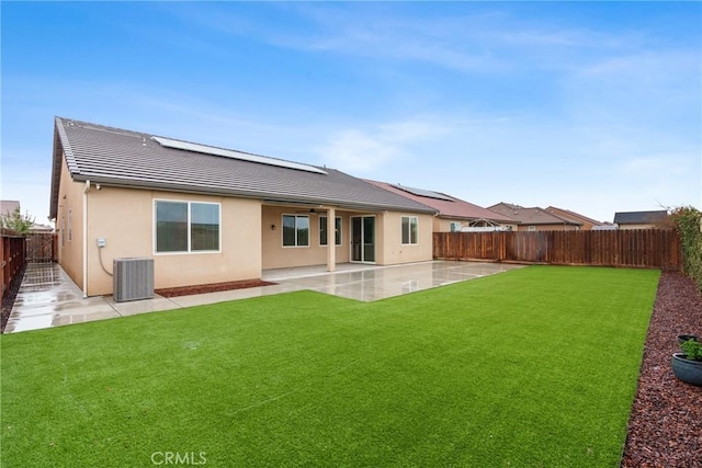 rear view of property featuring stucco siding, a lawn, a patio area, cooling unit, and a fenced backyard