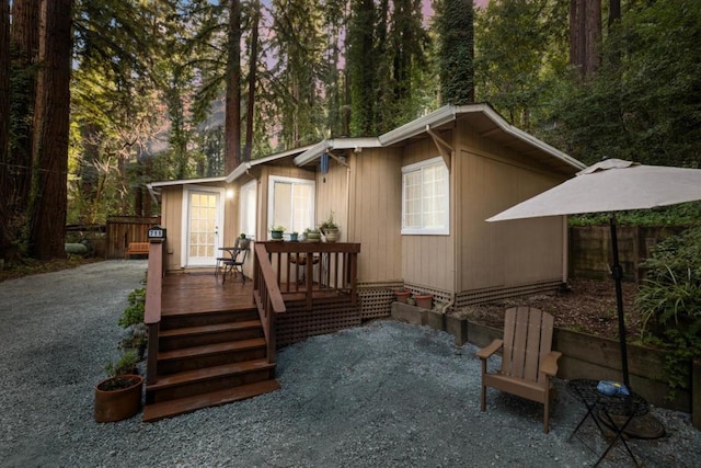 rear view of house featuring a wooden deck