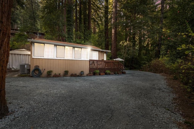 view of side of property with a wooden deck and central AC unit