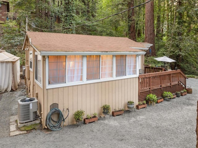 view of property exterior with a wooden deck and central air condition unit