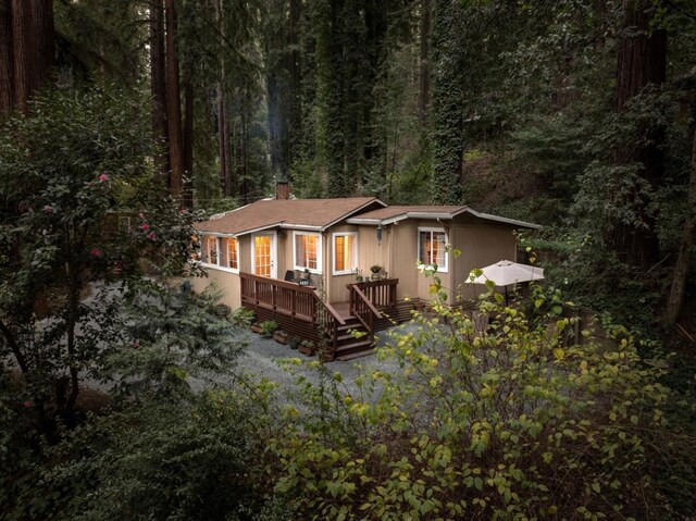 rear view of property featuring a wooden deck