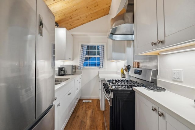 kitchen featuring white cabinetry, appliances with stainless steel finishes, and wall chimney range hood