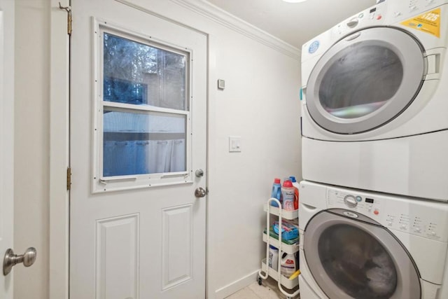 laundry area featuring ornamental molding, stacked washer / drying machine, and light tile patterned floors