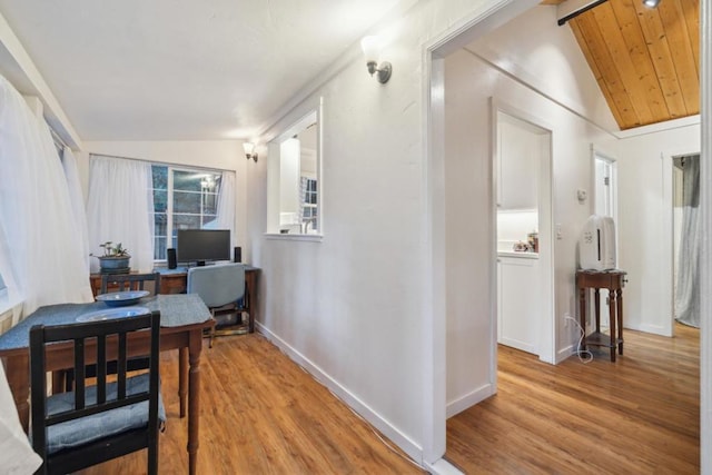 hall with lofted ceiling and light hardwood / wood-style flooring