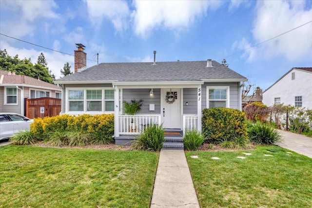 bungalow featuring a porch and a front lawn