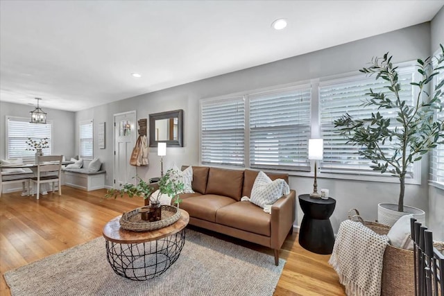 living room with light hardwood / wood-style floors and a notable chandelier