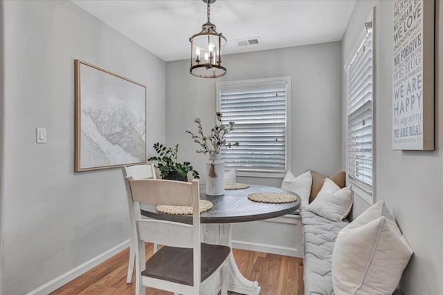 dining space featuring an inviting chandelier and light hardwood / wood-style flooring