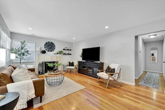 living room with a fireplace and light hardwood / wood-style flooring