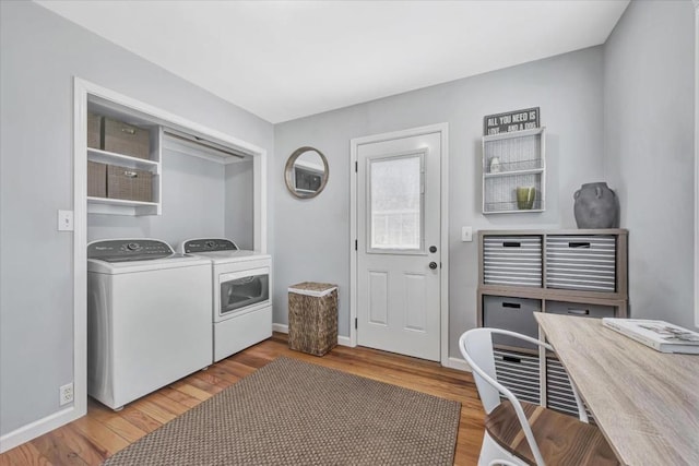 clothes washing area with separate washer and dryer and hardwood / wood-style flooring