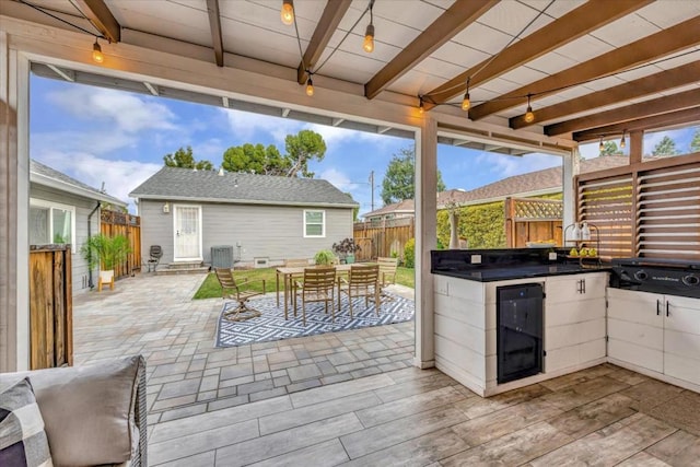 view of patio with cooling unit, an outdoor structure, and beverage cooler