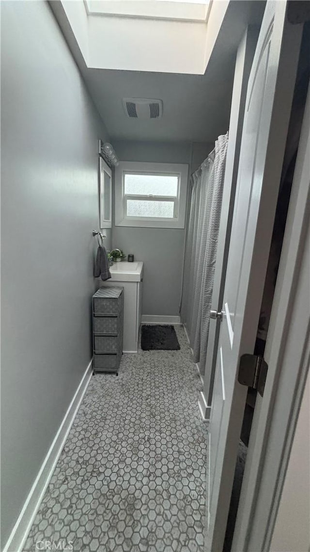 bathroom featuring vanity and a skylight