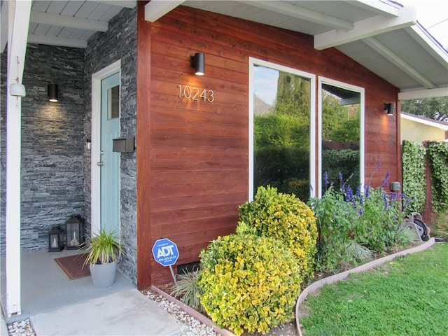 property entrance featuring stone siding