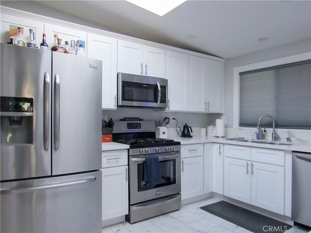 kitchen with white cabinetry, appliances with stainless steel finishes, and light countertops