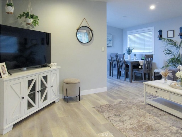 living area with light wood-style flooring and baseboards