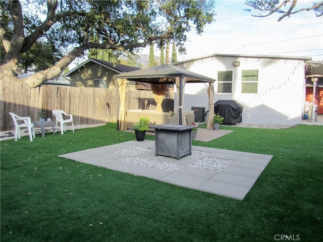 view of yard featuring a gazebo, central AC, a patio area, fence, and a fire pit