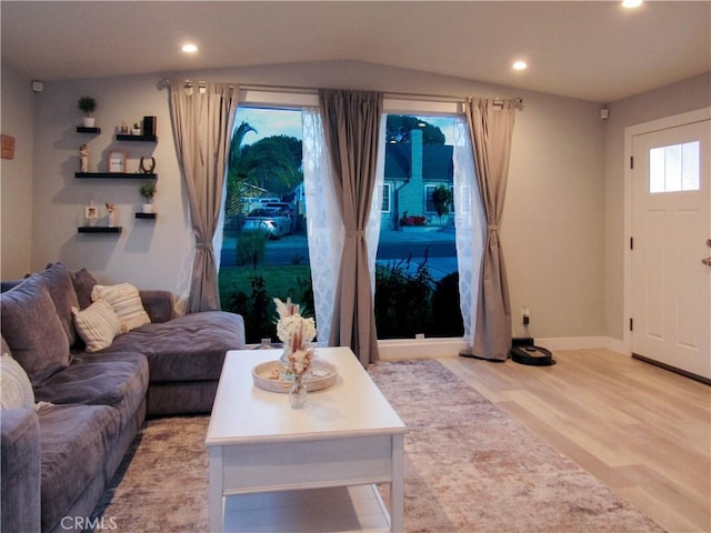 living room with baseboards, recessed lighting, lofted ceiling, and light wood-style floors