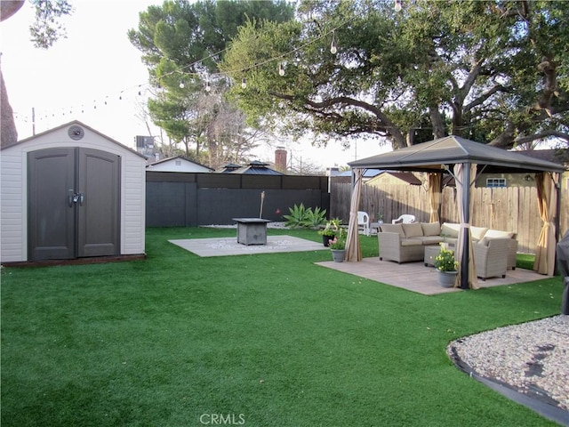 view of yard featuring an outbuilding, an outdoor living space with a fire pit, a storage unit, a gazebo, and a fenced backyard