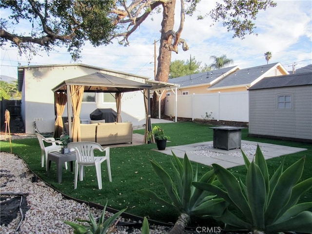 back of house featuring a fenced backyard, a gazebo, a lawn, a patio area, and an outdoor living space with a fire pit